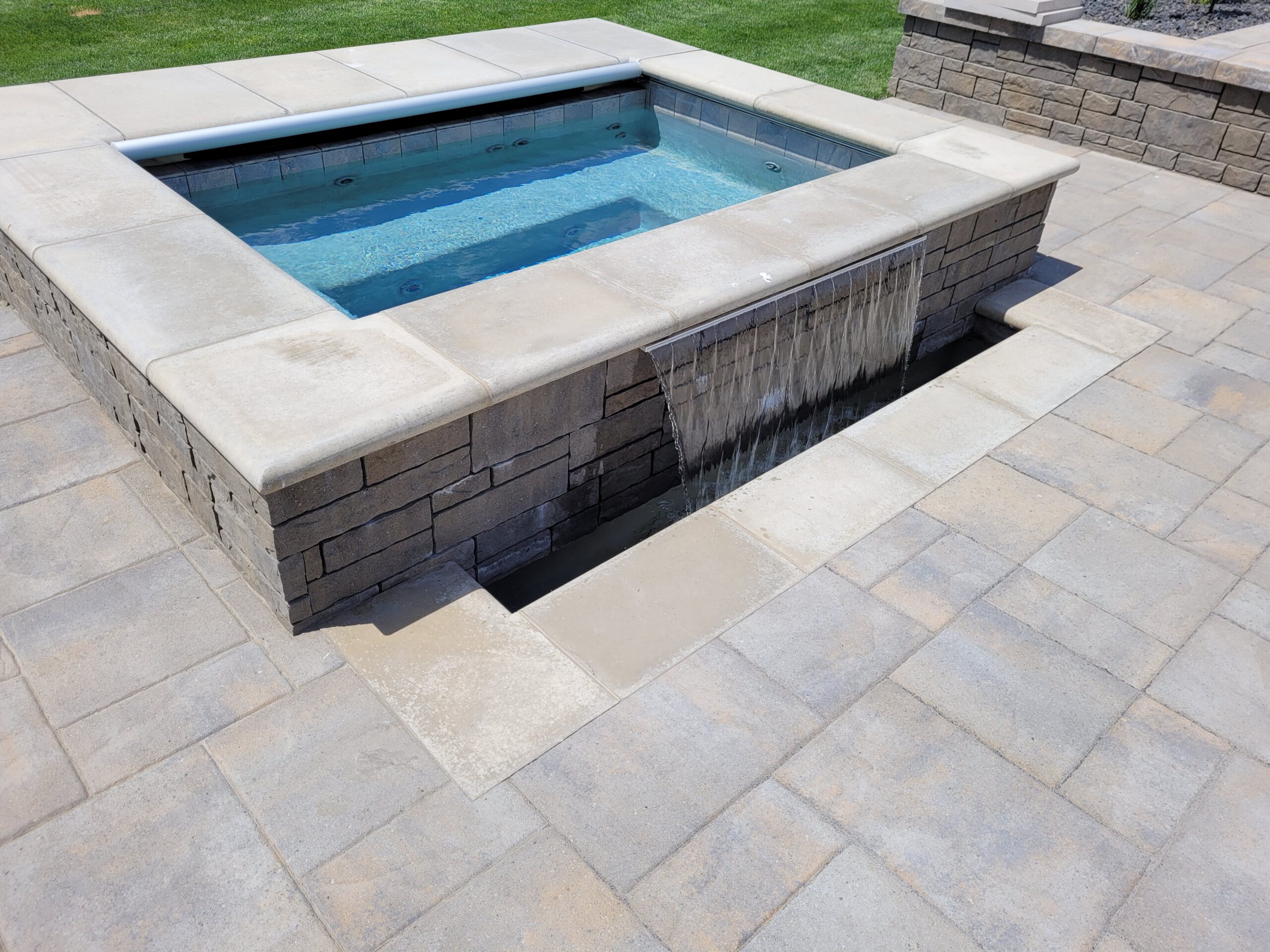 Raised tile spa spilling into the pool at Touchet Retreat, a custom pool built in Walla Walla, WA, WA by Outdoor Elements Northwest