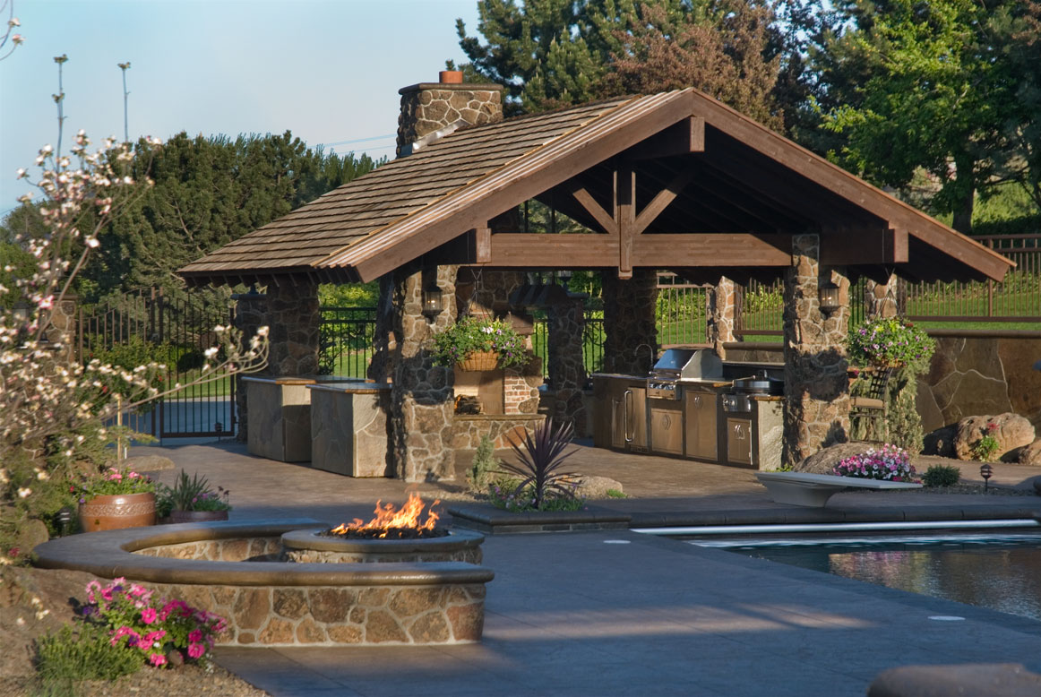 Fire feature burning beside the all-tile pool at Sunnyside Oasis, a custom pool built in Sunnyside, WA, WA by Outdoor Elements Northwest